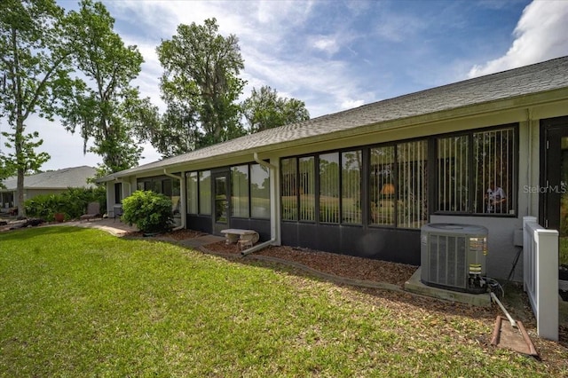 back of property with a yard and central air condition unit