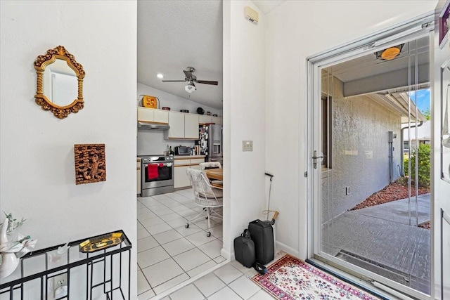 interior space with light tile patterned floors, ceiling fan, and vaulted ceiling