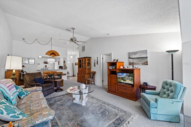living area featuring lofted ceiling, a textured ceiling, carpet flooring, visible vents, and a ceiling fan