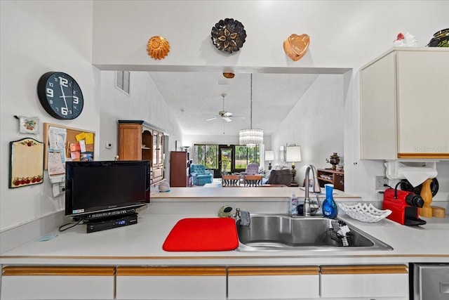 kitchen with ceiling fan, light countertops, vaulted ceiling with beams, and a sink