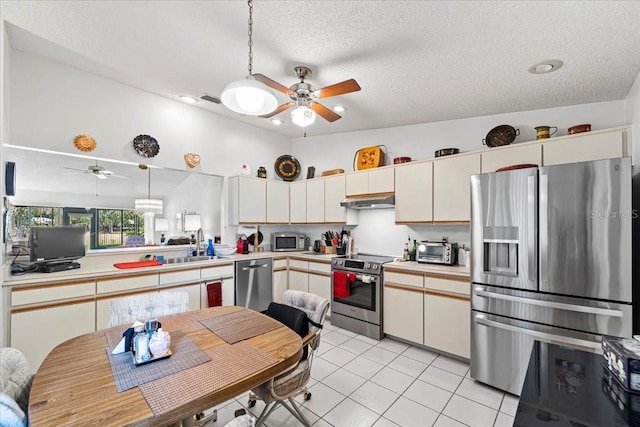 kitchen featuring stainless steel appliances, under cabinet range hood, light countertops, ceiling fan, and a textured ceiling