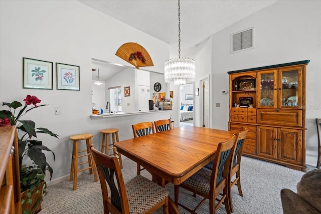 dining area featuring lofted ceiling, visible vents, baseboards, light carpet, and a notable chandelier