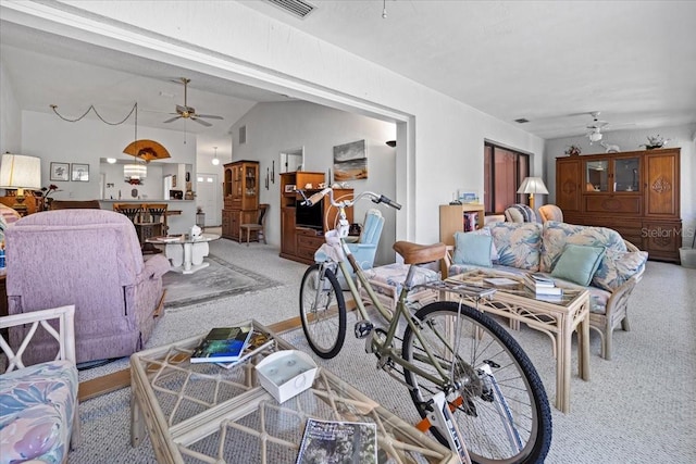 carpeted living room featuring a ceiling fan, visible vents, and lofted ceiling