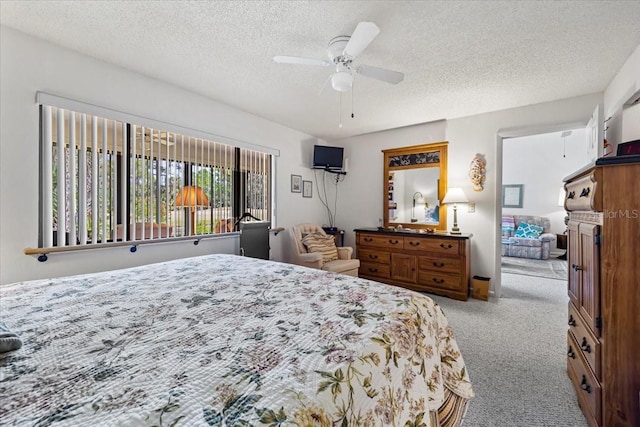 bedroom with carpet, a ceiling fan, and a textured ceiling