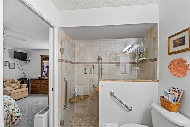 bathroom featuring toilet, a textured ceiling, and a shower stall