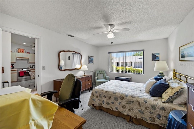 carpeted bedroom with visible vents, a ceiling fan, and a textured ceiling