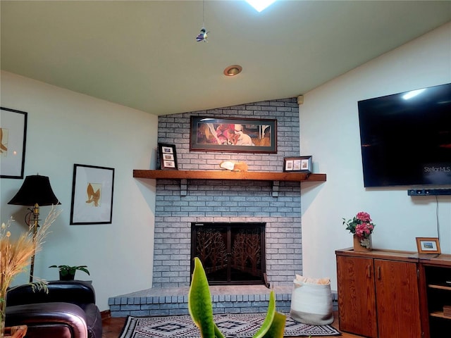 living area featuring lofted ceiling, a brick fireplace, and wood finished floors