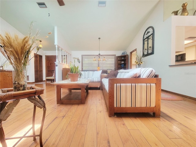 living area with a wealth of natural light, visible vents, and vaulted ceiling