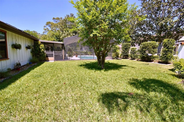 view of yard featuring glass enclosure and a fenced in pool