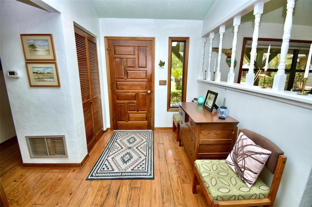 foyer featuring baseboards, visible vents, and hardwood / wood-style flooring