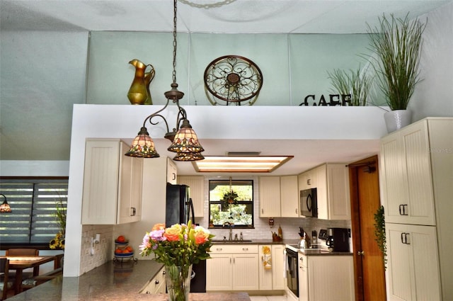 kitchen with a sink, dark countertops, backsplash, and black appliances