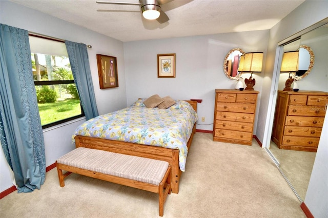 bedroom featuring baseboards, ceiling fan, and light colored carpet