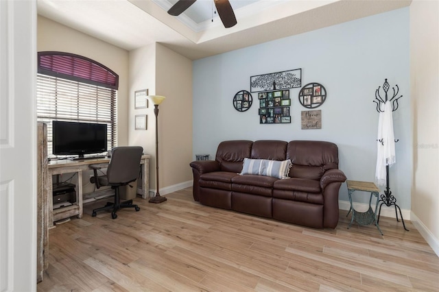 office with light wood finished floors, ceiling fan, a raised ceiling, and baseboards