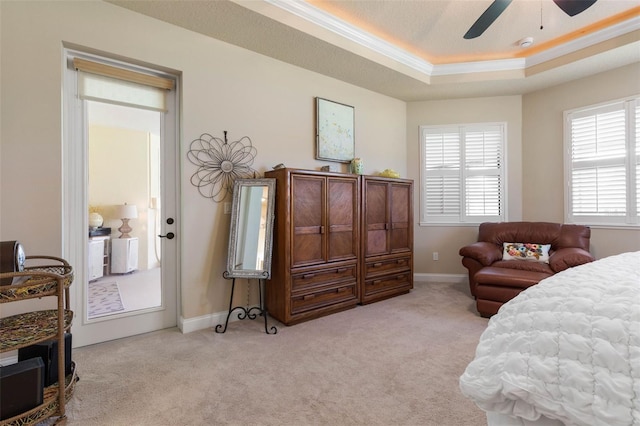bedroom featuring ornamental molding, light colored carpet, a raised ceiling, and baseboards