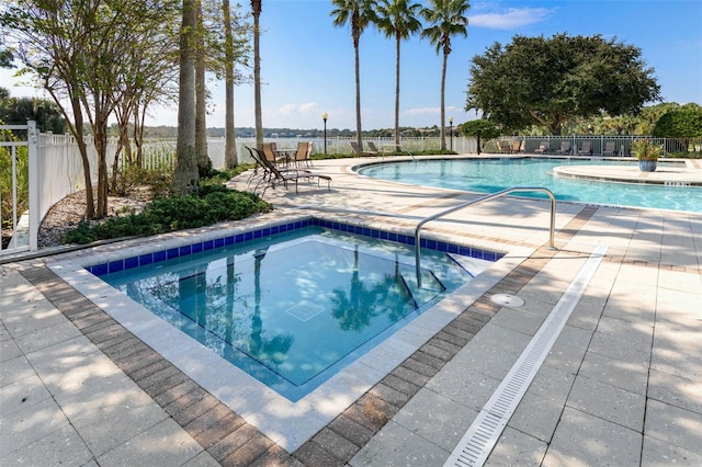 pool featuring a patio, a community hot tub, and fence