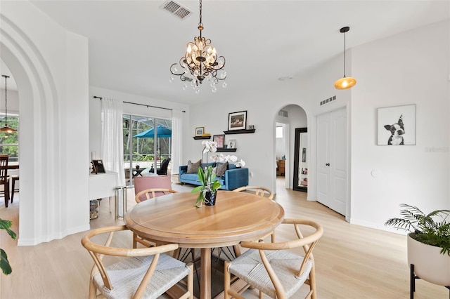 dining room with visible vents, a notable chandelier, and arched walkways
