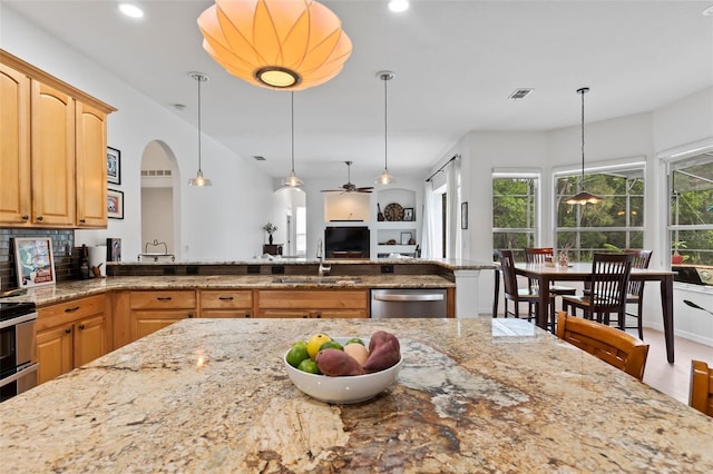 kitchen with visible vents, stainless steel dishwasher, light stone countertops, and a sink