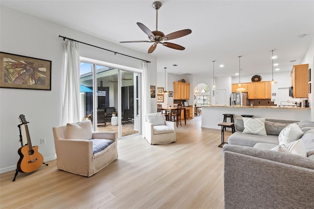 living room featuring recessed lighting, a ceiling fan, and light wood-style flooring