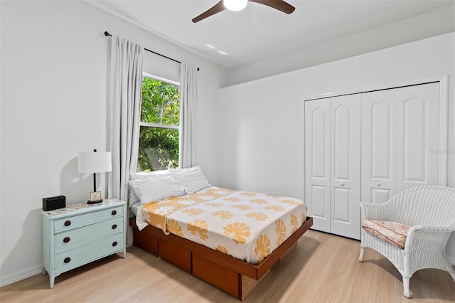 bedroom featuring a ceiling fan, a closet, and light wood finished floors