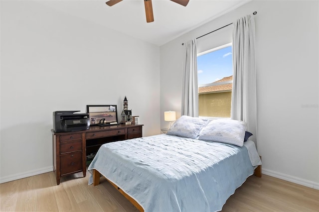 bedroom with ceiling fan, light wood-style flooring, and baseboards