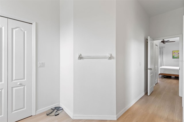hall with baseboards and light wood-style floors