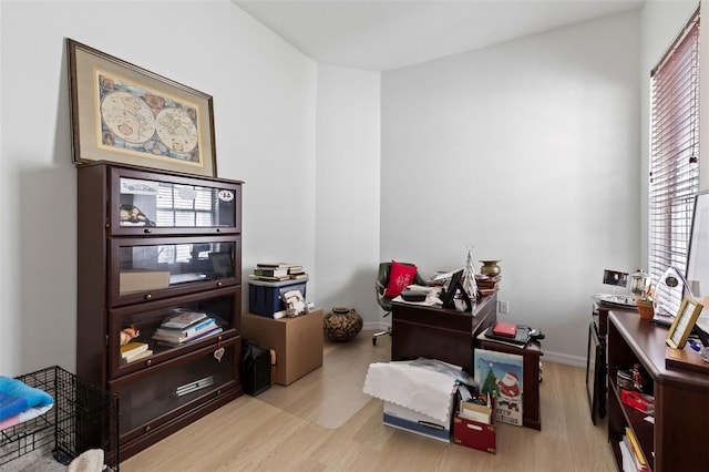interior space with baseboards and light wood finished floors