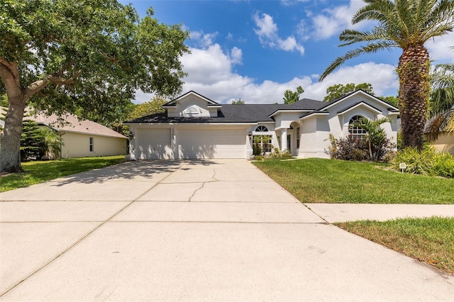 single story home featuring a garage, stucco siding, a front yard, and concrete driveway