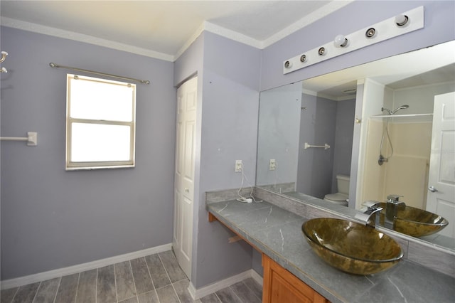bathroom featuring crown molding, vanity, toilet, baseboards, and wood finished floors