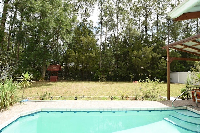 outdoor pool with a lawn and fence