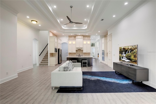 45 King Palm Ct, Ponte Vedra, FL 32081 - living area with arched walkways, a tray ceiling, crown molding, ceiling fan, and wood finished floors