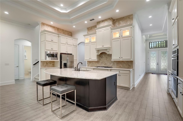 45 King Palm Ct, Ponte Vedra, FL 32081 - kitchen featuring stainless steel appliances, a sink, crown molding, arched walkways, and a kitchen breakfast bar