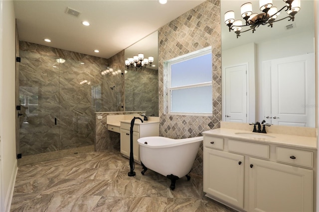 45 King Palm Ct, Ponte Vedra, FL 32081 - bathroom featuring marble tiled floors, a marble finish shower, a chandelier, two vanities, and a freestanding bath