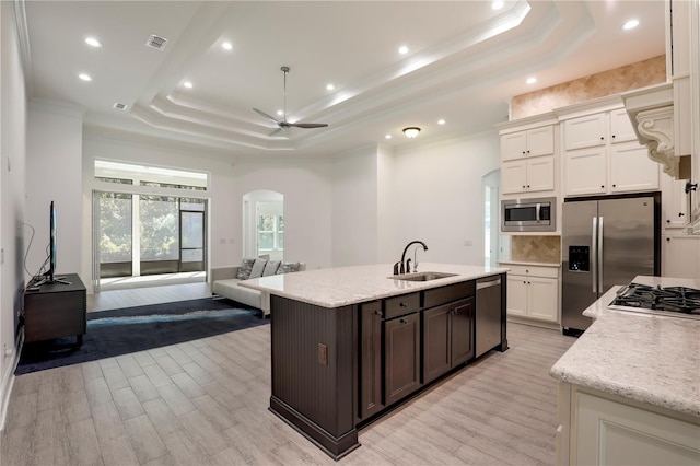 45 King Palm Ct, Ponte Vedra, FL 32081 - kitchen featuring a sink, stainless steel appliances, arched walkways, a raised ceiling, and ornamental molding