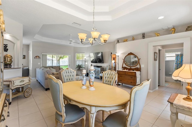 dining room with visible vents, light tile patterned floors, and a tray ceiling