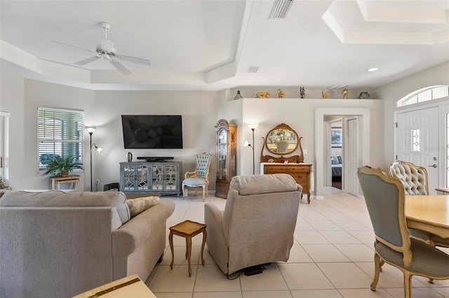 living room with light tile patterned floors, a raised ceiling, and visible vents