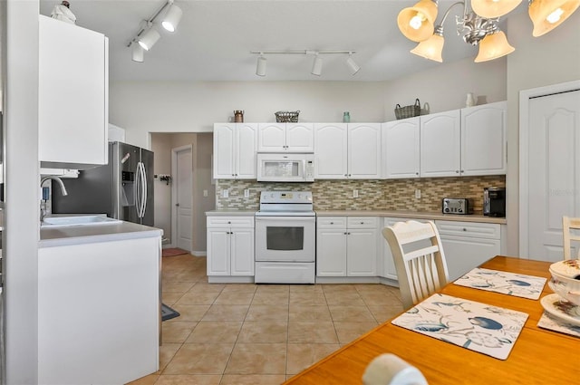 kitchen featuring decorative backsplash, light tile patterned floors, white cabinets, and white appliances
