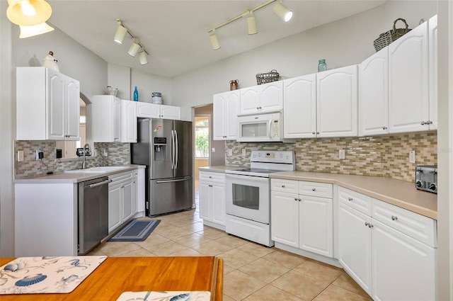 kitchen with a sink, white cabinetry, light tile patterned floors, and stainless steel appliances