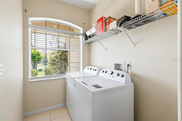 laundry area featuring baseboards, light tile patterned flooring, laundry area, and washer and clothes dryer
