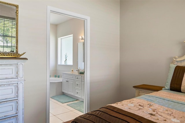 bedroom featuring light tile patterned floors, a sink, and connected bathroom