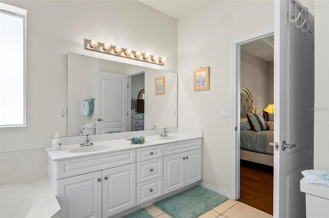bathroom with double vanity, a sink, ensuite bath, and tile patterned floors