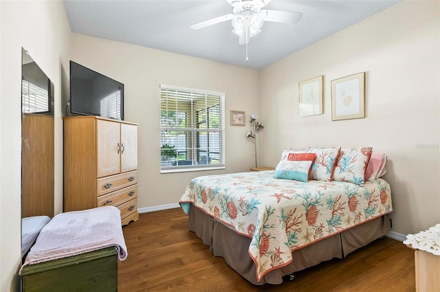 bedroom featuring a ceiling fan, baseboards, and wood finished floors