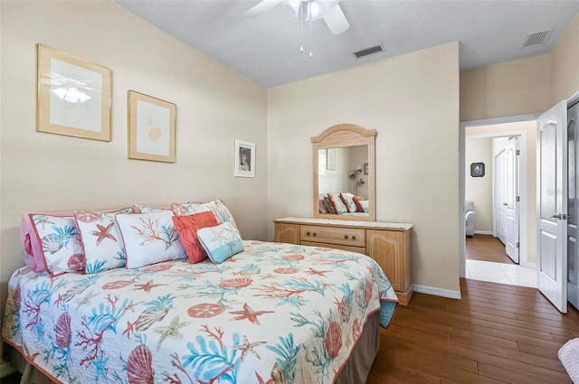 bedroom with visible vents, a ceiling fan, baseboards, and hardwood / wood-style floors