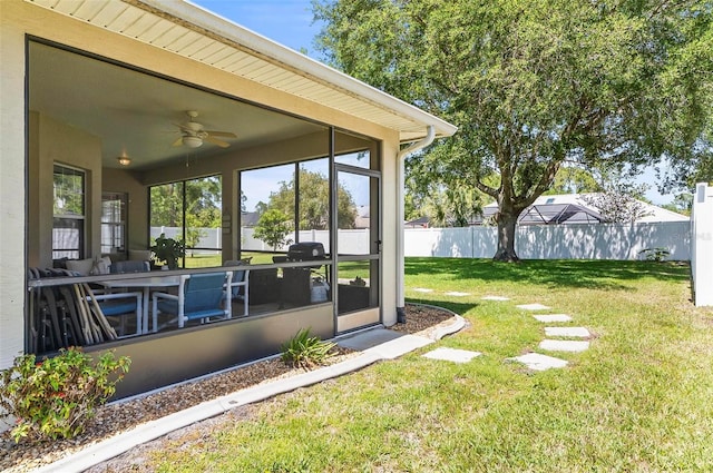 view of yard with ceiling fan, fence, and a sunroom