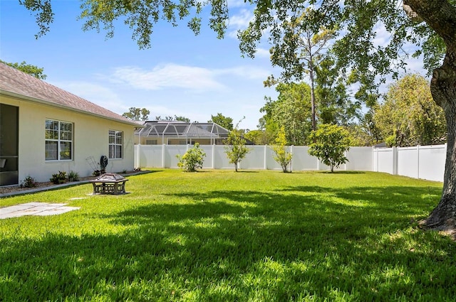 view of yard featuring a fenced backyard and a fire pit