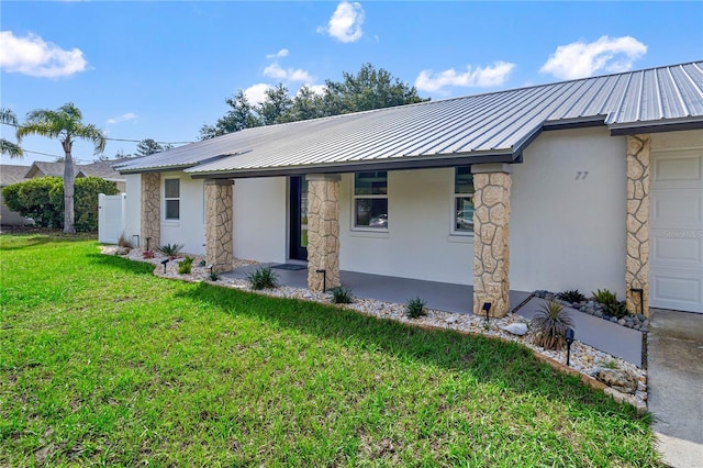 77 Freeport Ln, Palm Coast, FL 32137 - view of front of house with stone siding, stucco siding, a front yard, and metal roof