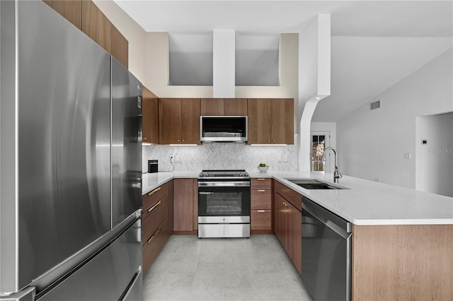77 Freeport Ln, Palm Coast, FL 32137 - kitchen with stainless steel appliances, a sink, a peninsula, backsplash, and modern cabinets