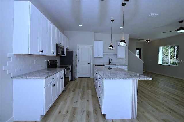1 Fanshawe Ln, Palm Coast, FL 32137 - kitchen featuring decorative backsplash, light wood-style flooring, a sink, a kitchen island, and electric range