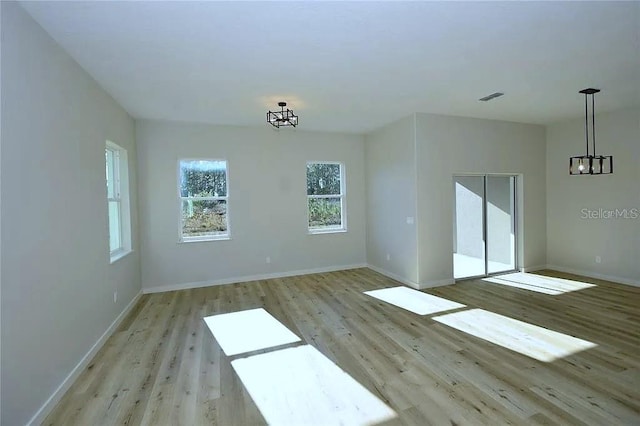 1 Fanshawe Ln, Palm Coast, FL 32137 - empty room featuring visible vents, an inviting chandelier, baseboards, and light wood-type flooring