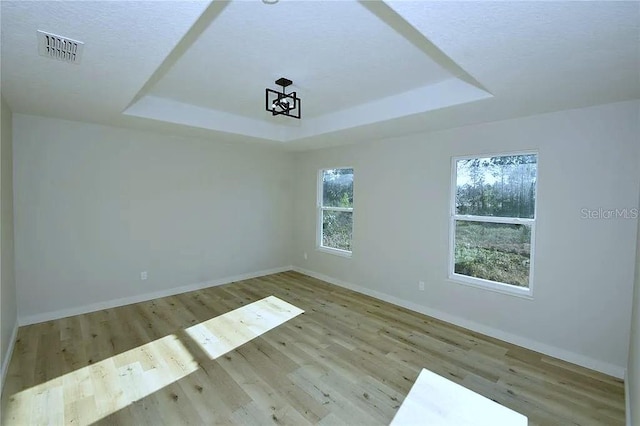 1 Fanshawe Ln, Palm Coast, FL 32137 - unfurnished room with baseboards, visible vents, wood finished floors, and a tray ceiling