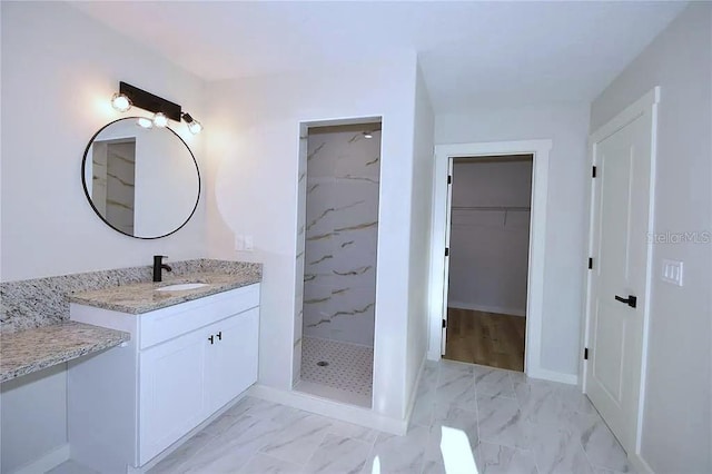 1 Fanshawe Ln, Palm Coast, FL 32137 - full bath with baseboards, a tile shower, marble finish floor, vanity, and a walk in closet